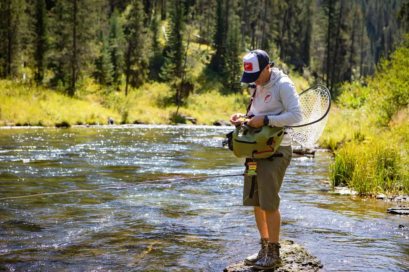 Fly box held open over river — choosing the right pattern for the hatch | Jackson Hole Fly Company