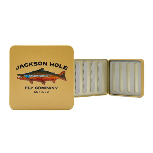 JHFLYCO Slim Metal Fly Box with brown trout artwork by Piper Nunn, Jackson Hole Fly Company lettering, and a golden background